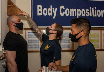 Service Member completing height portion of body composition assessment to determine military fitness  Photo by Petty Officer