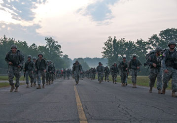 Soldiers on a road march fueled with performance nutrition tactics and Total Force Fitness strategies to maintain military we