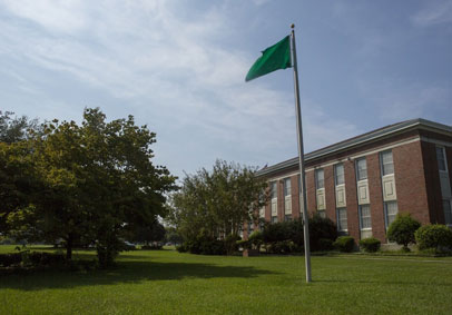 Green heat flag flies from military building communicating to those preparing for military workout how to prevent injury