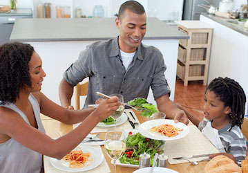 Military family eating healthy meal together to optimize military wellness and strengthen family relationships