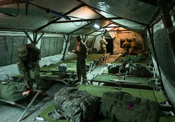 Soldiers preparing for bed in sleeping tent  Photo by Maj  Brandon Mace