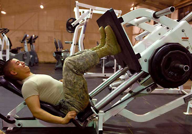Military member working out on a weight machine