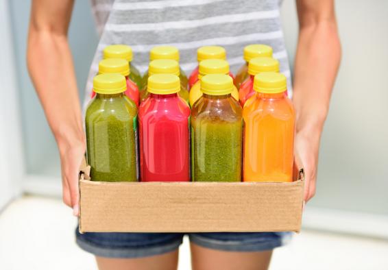 Person holds boxes of colorful juices but detox diets might not fuel military fitness