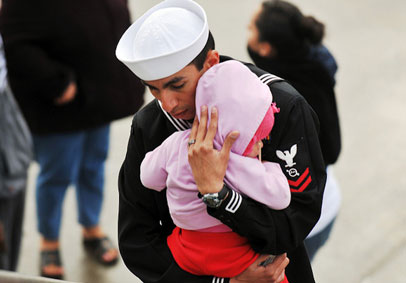 Sailor hugging his small daughter before leaving for military deployment  U S  Navy photo by Mass Communication Specialist Se
