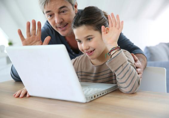 Father and daughter waving at computer screen to communicate and improve social support during deployment  