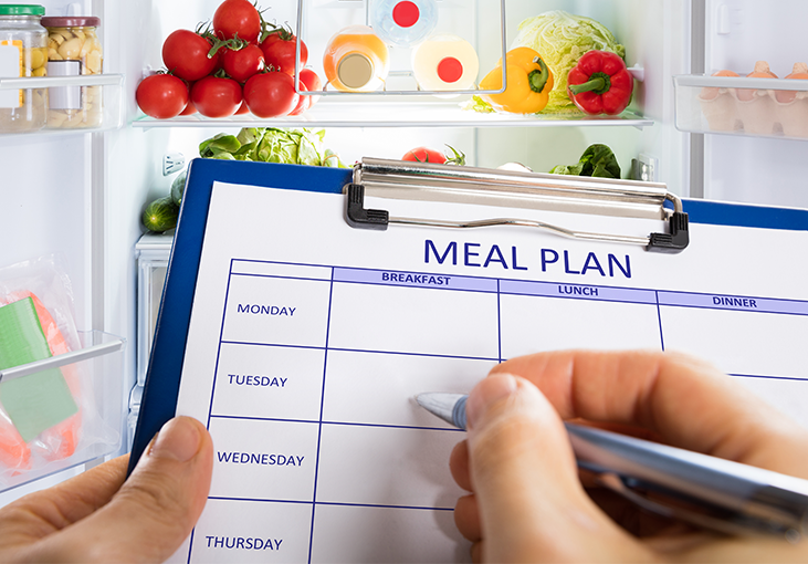 Meal plan worksheet on a clipboard in front of a fridge