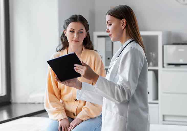 woman talking to a doctor reviewing a list