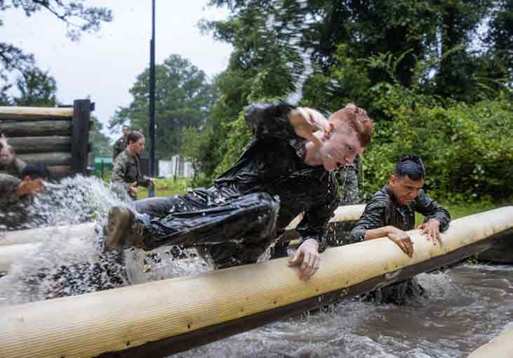 man jumping over log in water