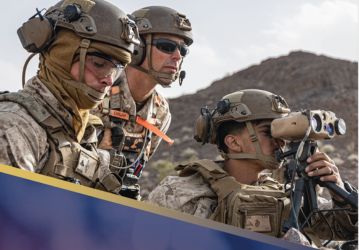 Servicemembers looking out with sunglasses and one looking through binoculars